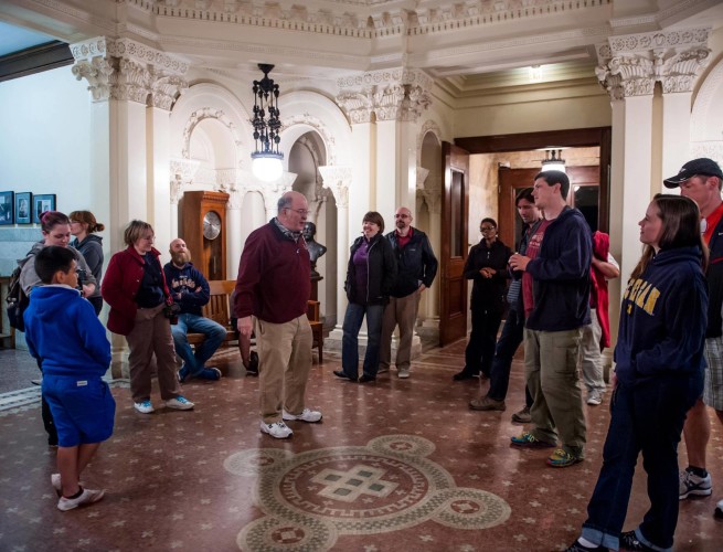 A group of people watch the docent in the lobby of the Yerkes Observatory.