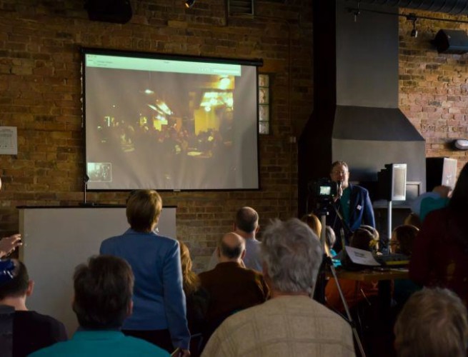 Chicago Skepticamp watches a screen projecting a live-stream of Escepticamp Madrid