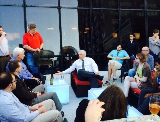 Dr. Steven Novella seated in the center of a group of people